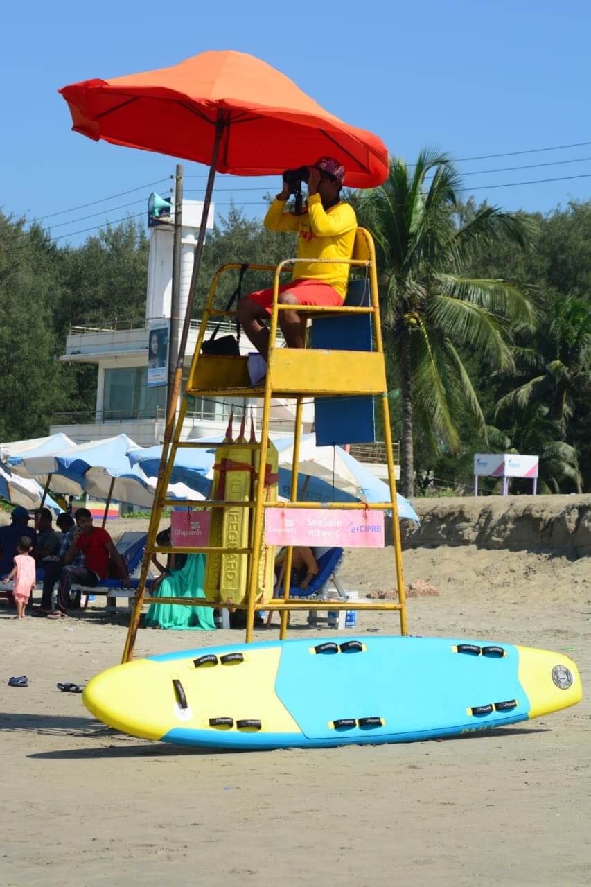 Life guard with red rescue infatable rescue board in cox's bazaar - bangladesh