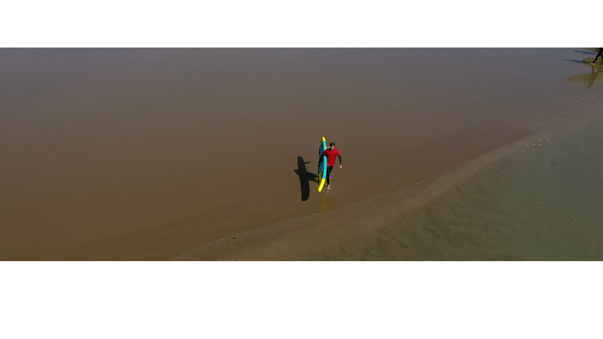 Lifeguard with inflatable rescue board on beach