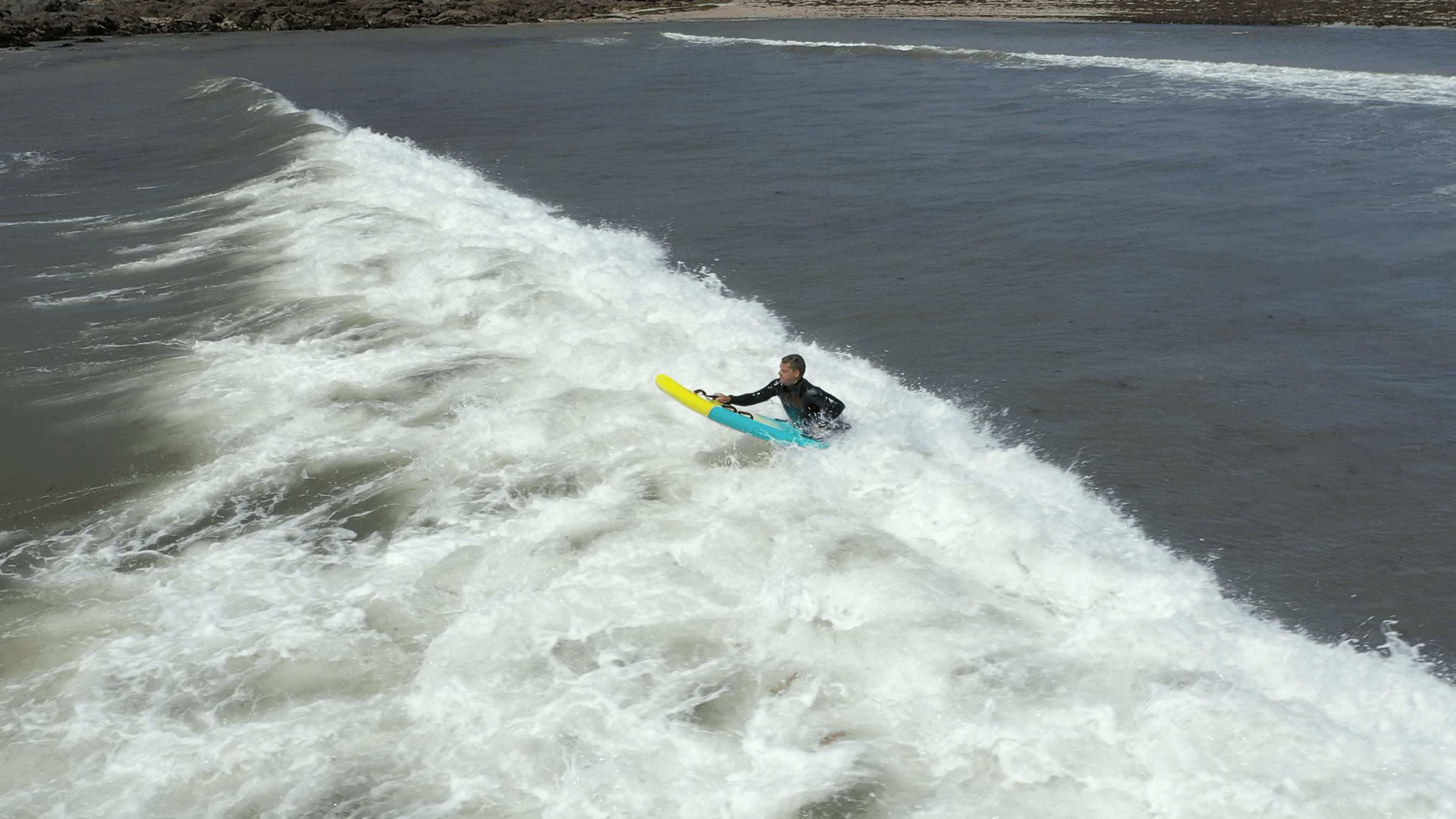 lifeguard punching through surf on infklatable prone surf rescue board