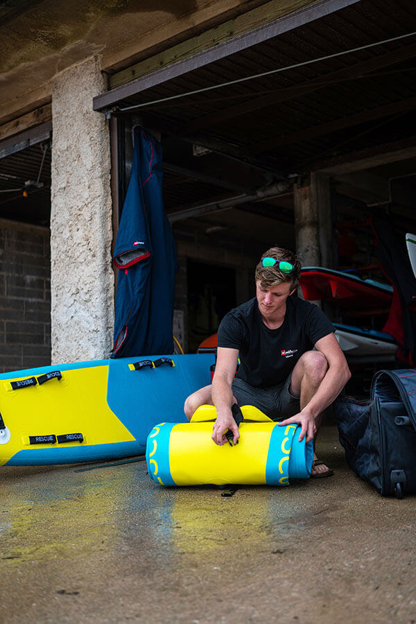 unrolling inflatable rescue boat at surf lifesaving club